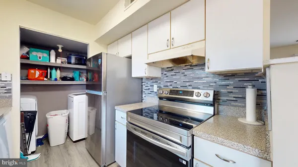 a kitchen with stainless steel appliances granite countertop a refrigerator and a stove top oven