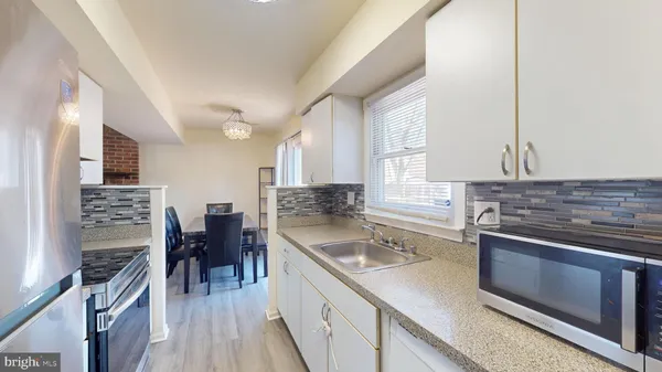 a kitchen with stainless steel appliances granite countertop a sink dishwasher stove and refrigerator