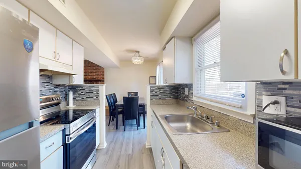 a kitchen with granite countertop a sink a counter space appliances and cabinets
