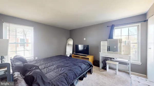 a bedroom with a bed and a large window