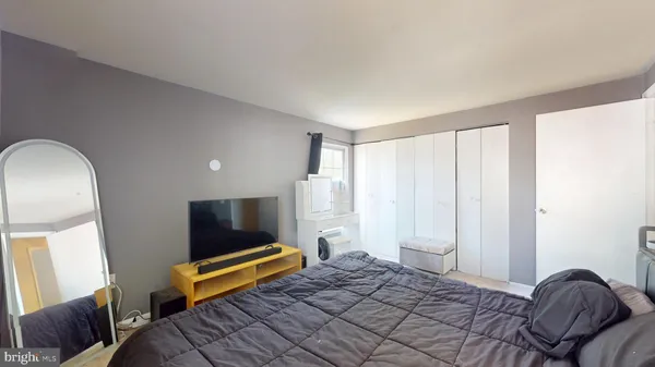 a bedroom with a bed and flat screen tv