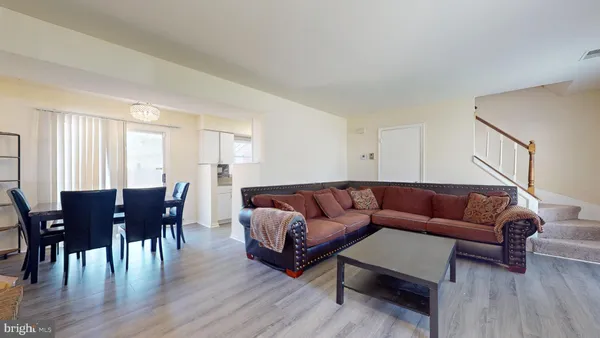 a living room with furniture wooden floor and dining table