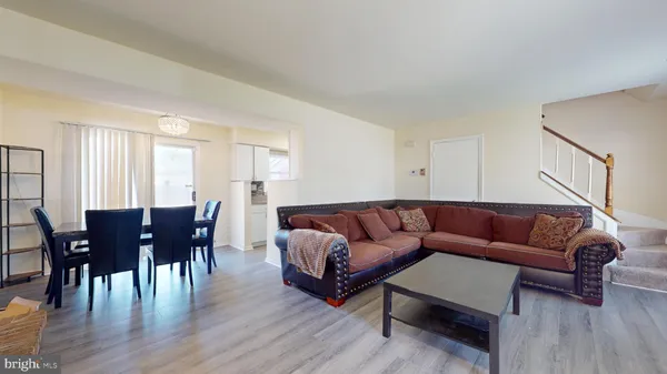 a living room with furniture wooden floor and dining table