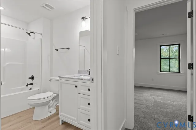 a bathroom with a granite countertop sink a mirror and shower