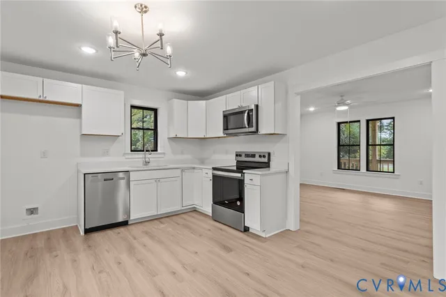 a kitchen with a white appliances cabinets and a wooden floor