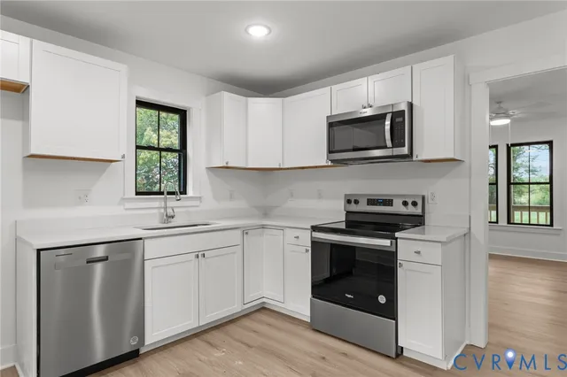 a kitchen with white cabinets stainless steel appliances and sink