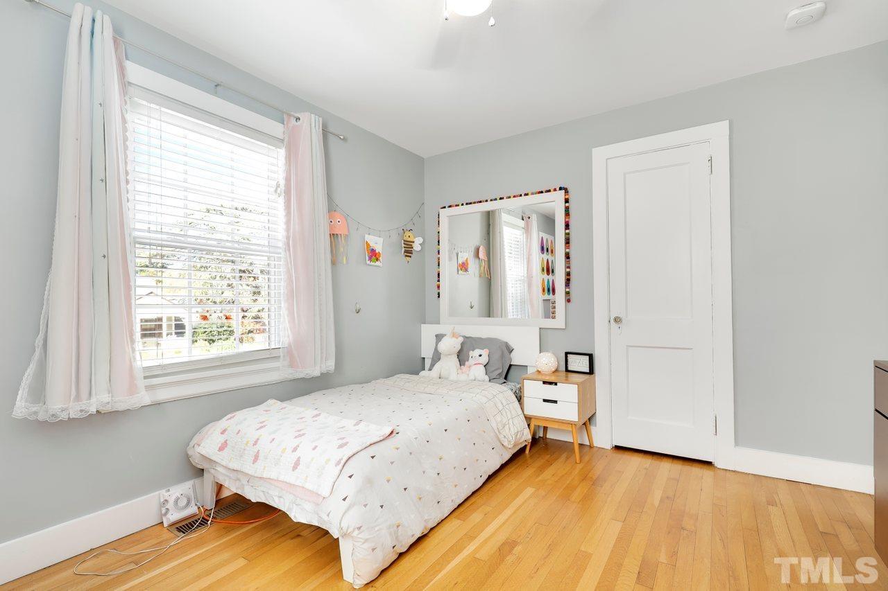 1110 Watauga Street Raleigh, NC 27604 - Photo 22 of 30 a bedroom with a bed and wooden floor