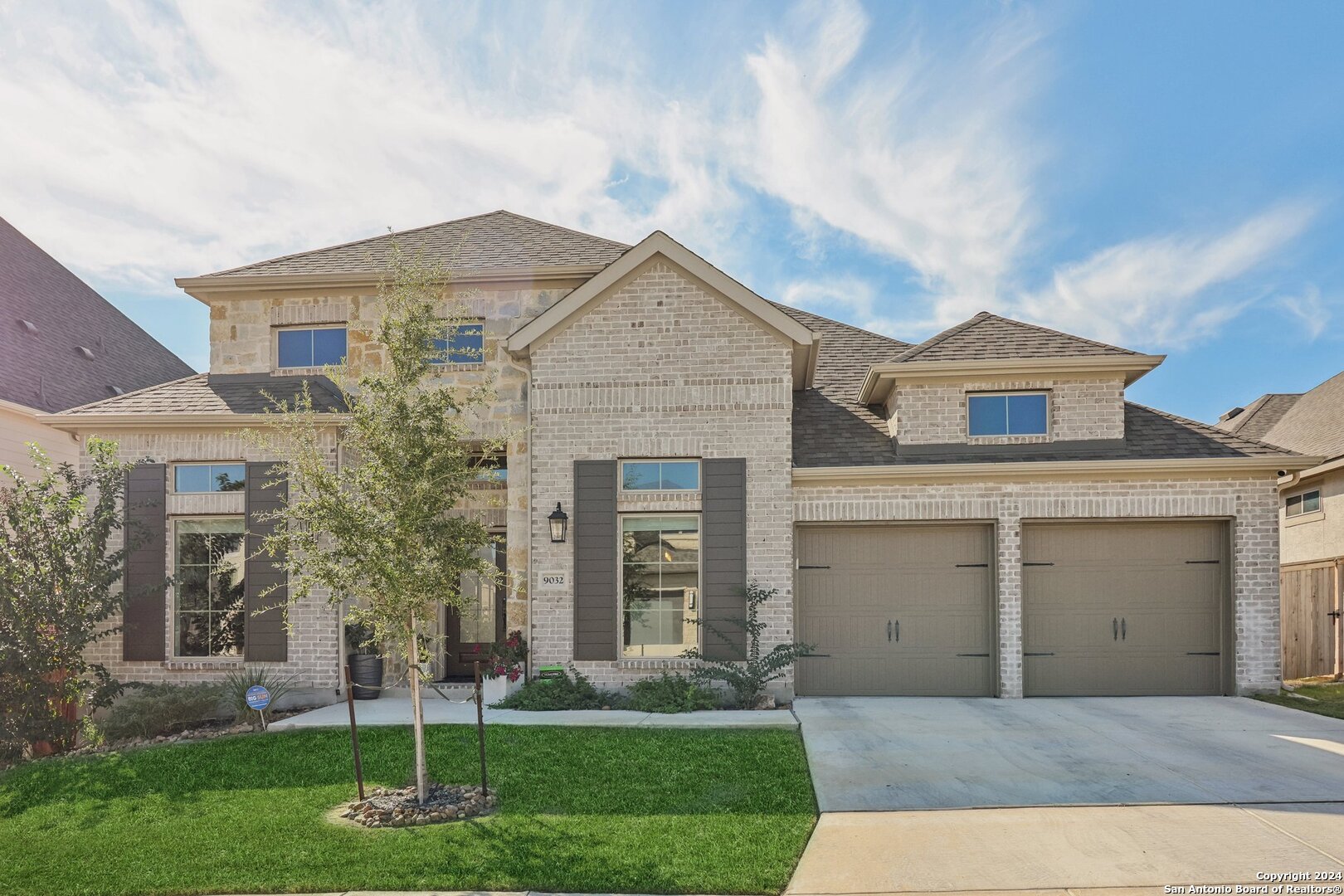 a front view of a house with a yard and garage