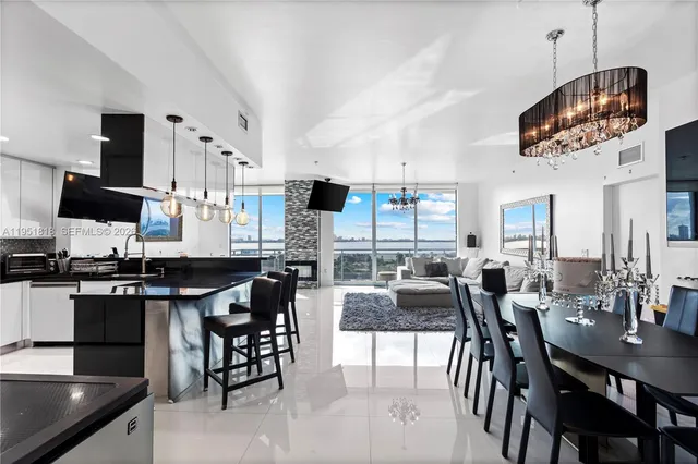 a kitchen with stainless steel appliances granite countertop a stove top oven a sink a dining table and chairs