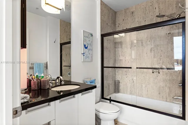 a bathroom with a sink a toilet and a large mirror