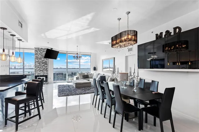 a dining room with wooden floor a chandelier a wooden table and chairs