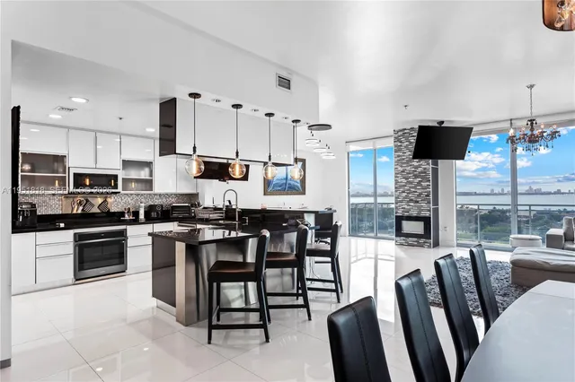 a large kitchen with stainless steel appliances microwave stove refrigerator and table