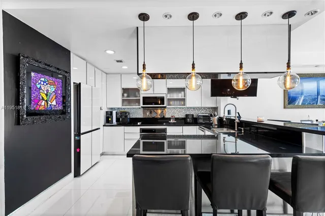 a kitchen with stainless steel appliances kitchen island granite countertop a stove a sink and a microwave
