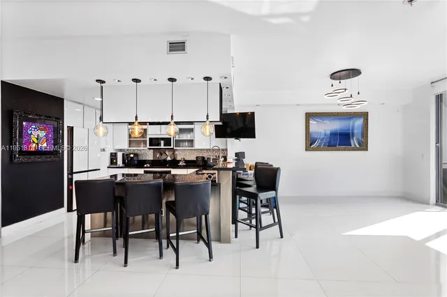 a kitchen with stainless steel appliances a table and chairs in it