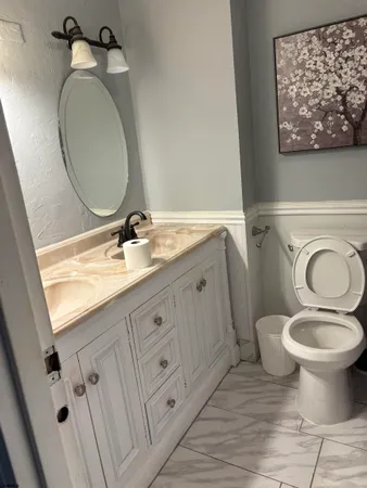 a bathroom with a toilet sink and mirror