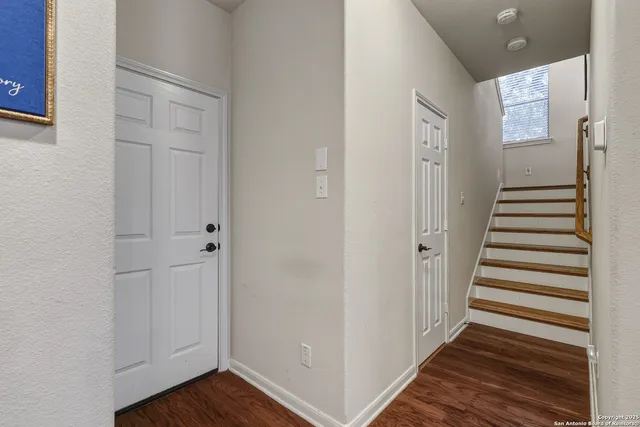a view of a hallway with wooden floor and entryway