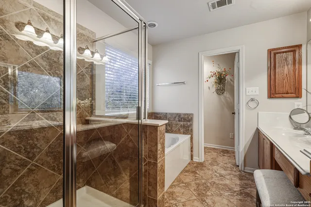 a bathroom with a granite countertop sink a mirror and shower