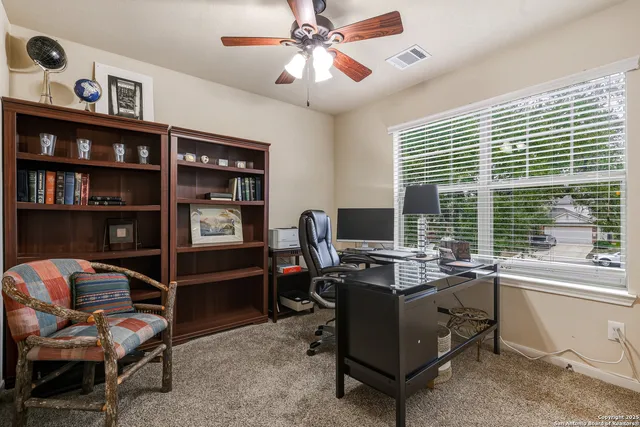 a view of a workspace with furniture and a window