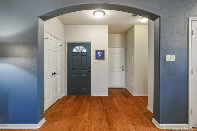 a view of a hallway with wooden floor and closet