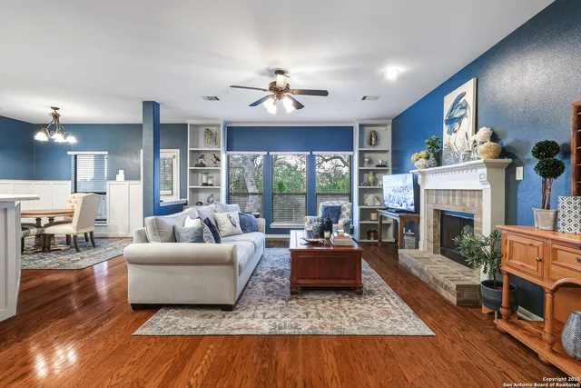 a living room with furniture large window and a fireplace