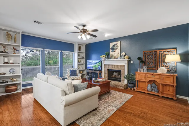 a living room with furniture a fireplace and a large window