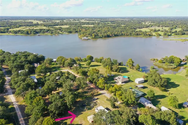 an aerial view of residential houses with outdoor space and lake view