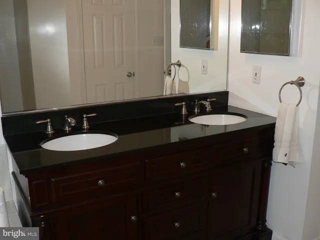 a bathroom with double sink and a mirror