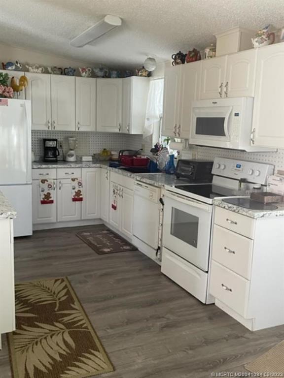 2526 Southwest Olds Place Stuart, FL 34997 - Photo 5 of 11 a kitchen with white cabinets and white appliances