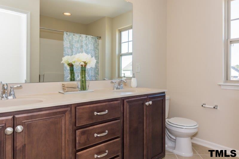 4221 Fares Wall Court Raleigh, NC 27616 - Photo 21 of 25 a bathroom with a granite countertop toilet sink and mirror