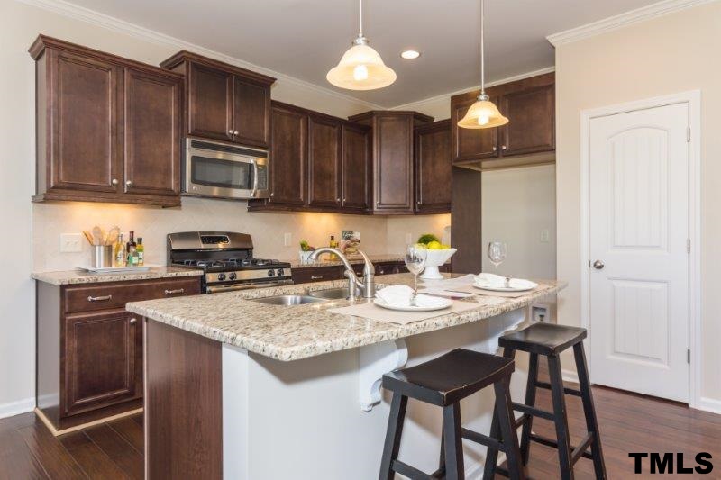 4221 Fares Wall Court Raleigh, NC 27616 - Photo 6 of 25 a kitchen with stainless steel appliances granite countertop a stove top oven a refrigerator a sink and dishwasher with wooden floor