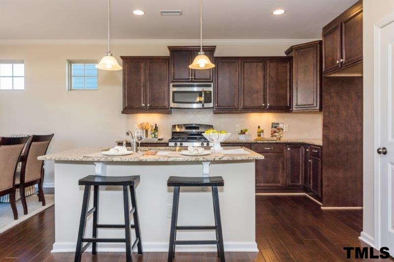 4221 Fares Wall Court Raleigh, NC 27616 - Photo 7 of 25 a kitchen with granite countertop wooden floors cabinets a sink and appliances