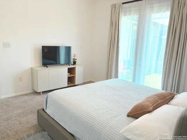 a bedroom with a bed and a flat screen tv