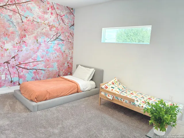 a bedroom with a bed and a painting on the wall
