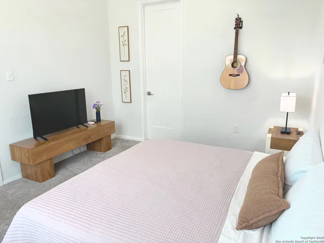 a bedroom with a bed and a flat screen tv
