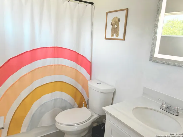 a bathroom with a toilet a sink and a mirror