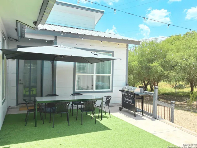 a view of backyard with a table and chairs