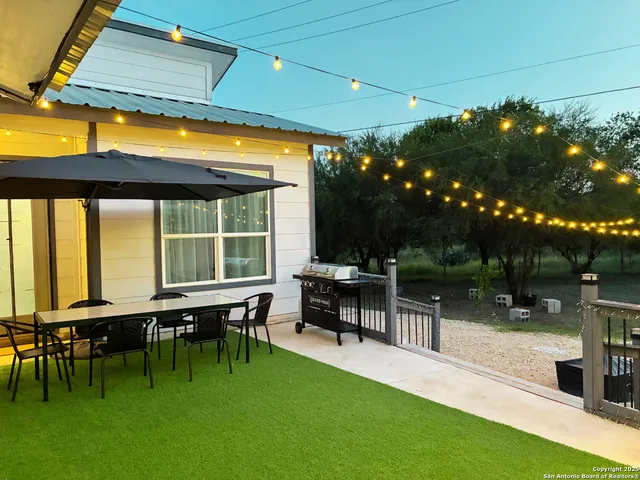 a view of a patio with table and chairs with wooden floor and fence