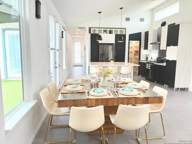 a dining room with furniture and a large window