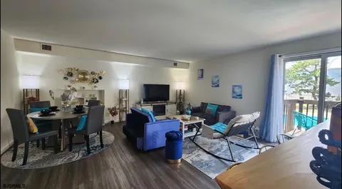 a living room with furniture a large window and a dining table
