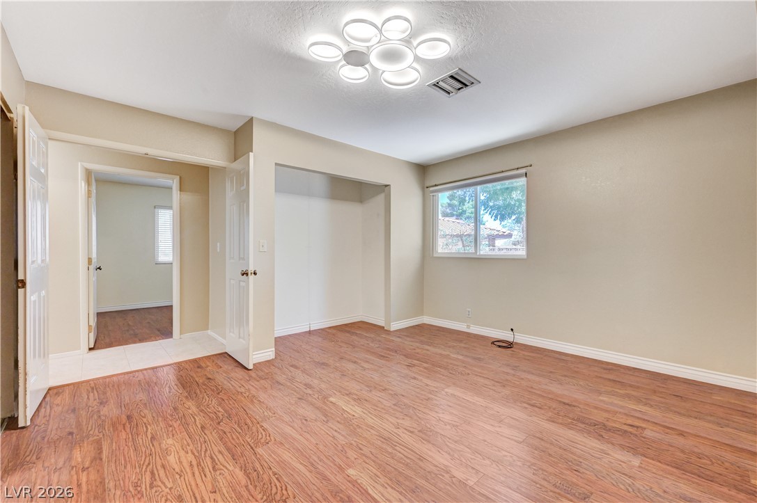 7631 Bermuda Road Las Vegas, NV 89123 - Photo 21 of 64 Natural wood flooring complements this inviting bedroom with ample light.