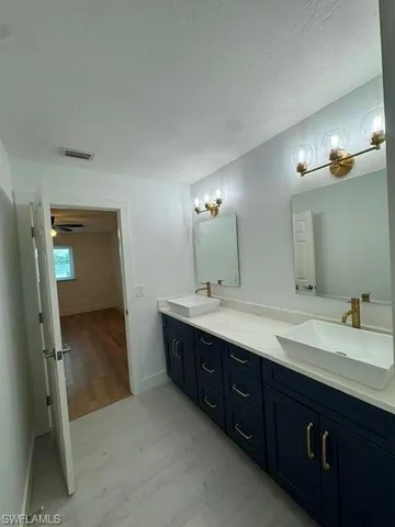 a spacious bathroom with a double vanity sink and mirror