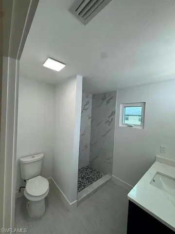 a bathroom with a toilet sink and shower