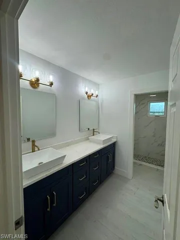 a bathroom with a double vanity sink and mirror