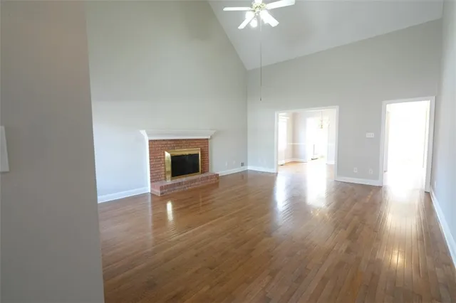 a view of empty room with wooden floor and fireplace