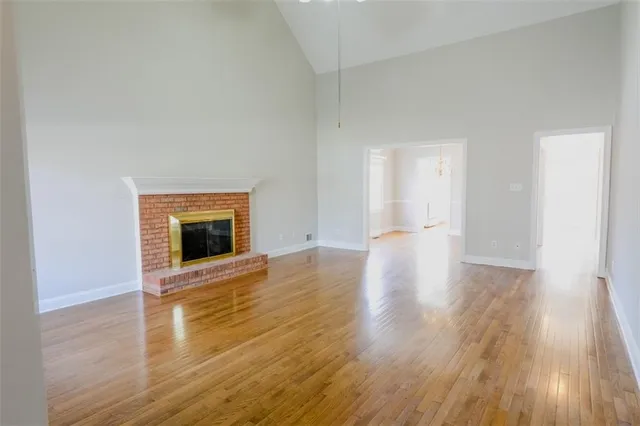 a view of a livingroom with wooden floor and a fireplace