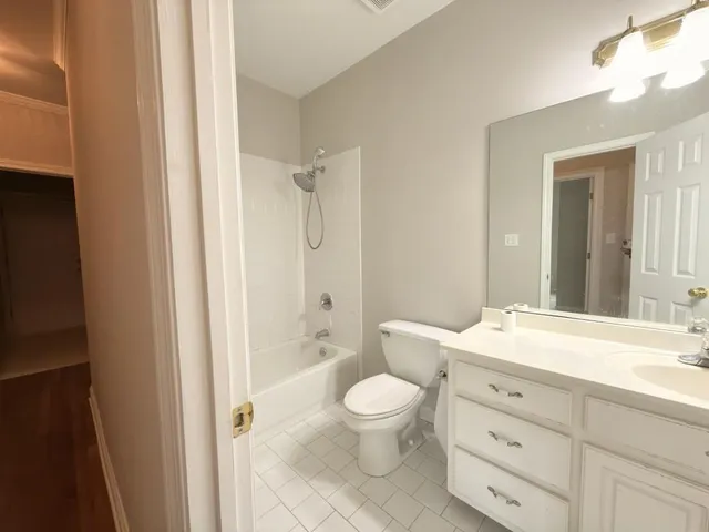 a bathroom with a granite countertop toilet a sink and a bathtub