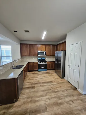a large kitchen with kitchen island granite countertop a large counter top stainless steel appliances and cabinets