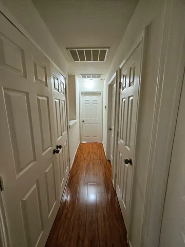a view of a hallway with wooden floor and staircase