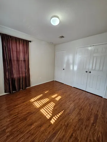a view of an empty room with wooden floor