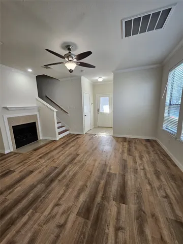 a view of a livingroom with wooden floor ceiling fan and window
